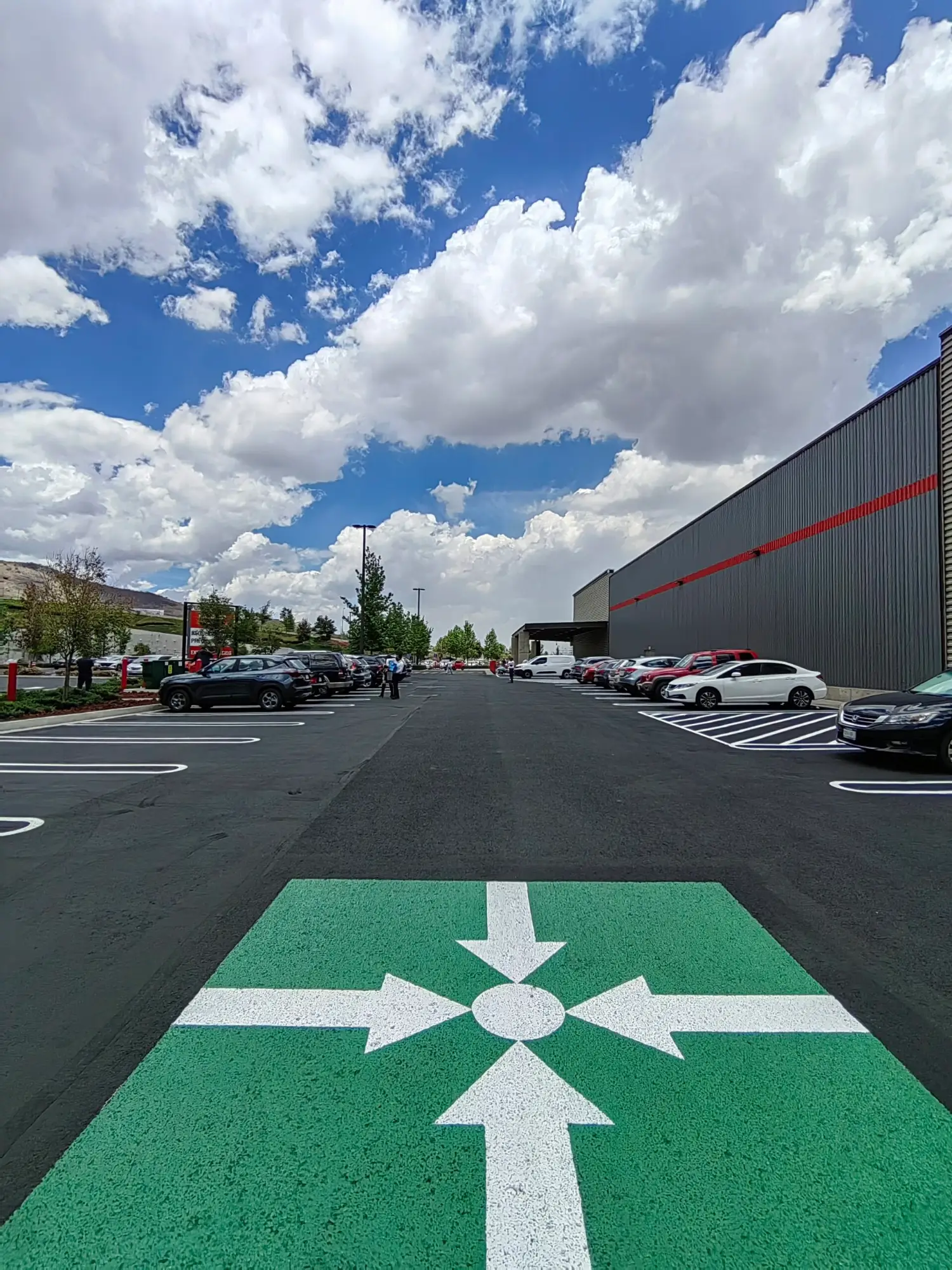 Estacionamiento comercial recién sellado por FG Ingeniería, con líneas de cajón y símbolos de accesibilidad recién pintados.